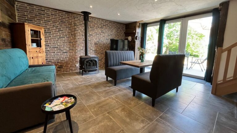 Salon donnant sur terrasse de plein pied, réservation de nuitées dans une maison à la campagne avec espace bien-être, jacuzzi et sauna entièrement privatif.