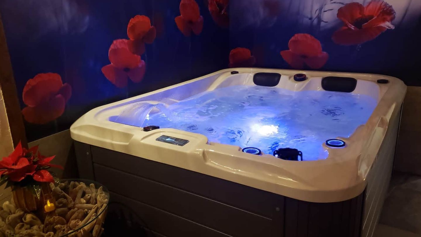 Jacuzzi avec lumières de différentes couleurs au choix, réservation de nuitées dans une maison à la campagne avec espace bien-être, jacuzzi et sauna entièrement privatif.